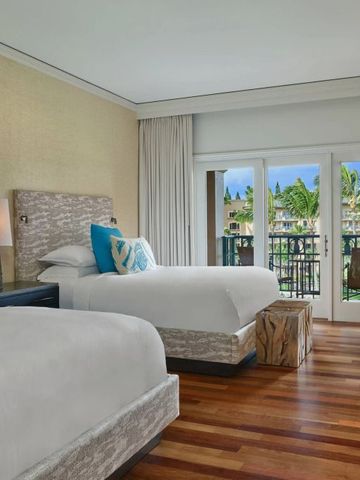 Elegantes Doppelzimmer mit großen Fenstern und tropischem Ausblick