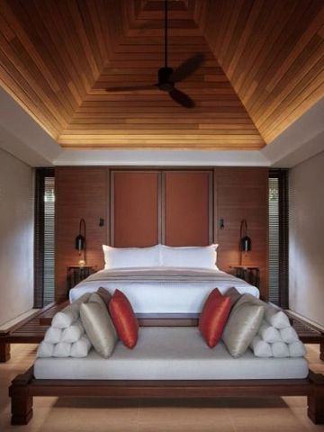 Luxuriös eingerichtetes Schlafzimmer mit Holzdecke und hochwertiger Bettwäsche