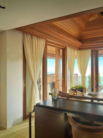 Essbereich mit Holzelementen und Blick auf das Meer durch große Fensterfront