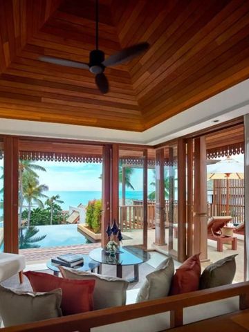 Wohnzimmer mit hochwertiger Holzdecke, Poolblick und Zugang zur Terrasse