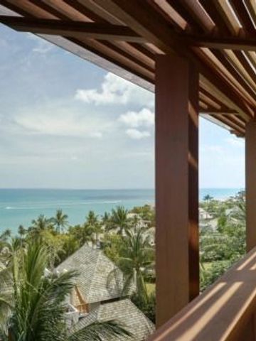Atemberaubender Blick auf Palmen und den Ozean von einem hölzernen Balkon aus