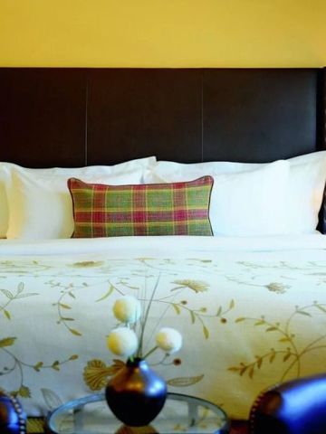 Bequemes Kingsize-Bett mit floralem Dekor und weichen Kissen in einem luxuriösen Zimmer