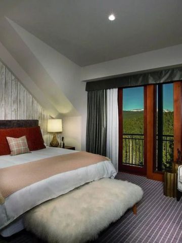 Helles Schlafzimmer mit Blick auf den Wald und stilvoller moderner Einrichtung