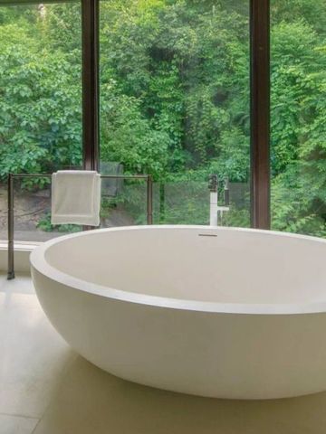 Luxuriöse runde Badewanne mit Waldblick