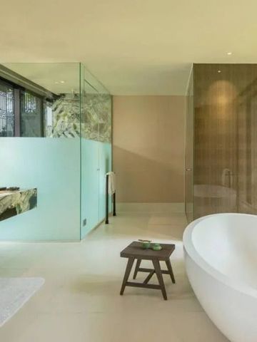 Elegantes Badezimmer mit runder Badewanne und Glasdusche