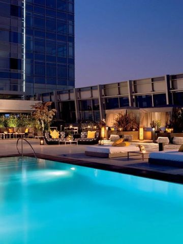 Abendstimmung am beleuchteten Außenpool des Hotels mit eleganten Loungemöbeln