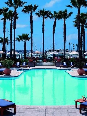 Pool umgeben von Palmen mit Blick auf den Yachthafen