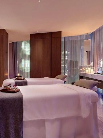 Spa-Behandlungsraum mit zwei Massageliegen und Stadtansicht