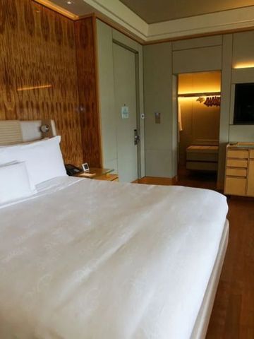 Luxuriöses Hotelzimmer im Ritz-Carlton Millenia Singapore mit Holzdekorwand und großem Bett