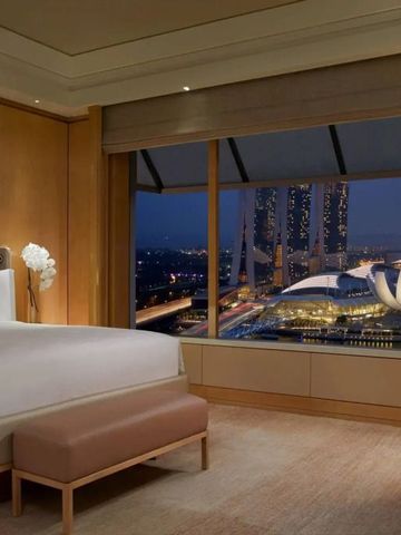 Komfortables Zimmer mit Panoramafenster und Blick auf Marina Bay Sands
