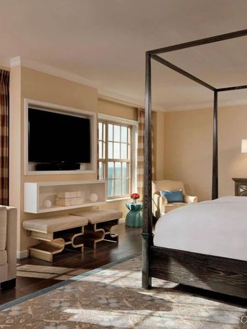 Zimmer mit Himmelbett, Sitzbereich und modernem Dekor