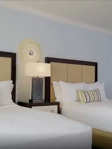 Zimmer mit zwei Doppelbetten und stilvoller Einrichtung