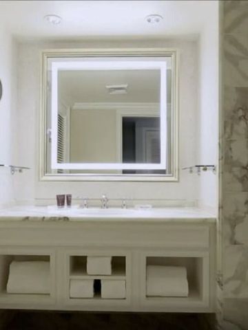 Modernes Badezimmer mit weißem Waschtisch und großem Spiegel