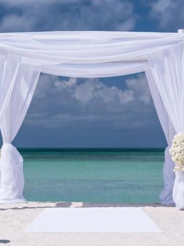 Weiße Hochzeitskapelle am Strand mit Blick auf das blaue Meer