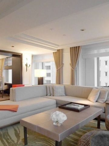 Geräumiges Wohnzimmer einer Suite mit modernen Möbeln und großen Fenstern