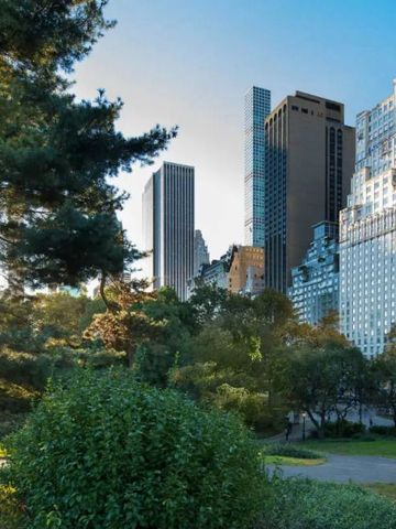 Landschaftsaufnahme des Central Parks mit Wolkenkratzern im Hintergrund bei Sonnenuntergang.