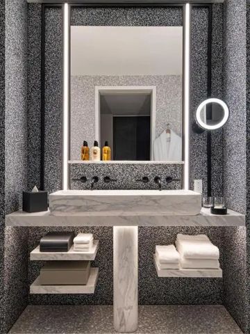 Modernes Badezimmer mit beleuchtetem Spiegel und grauen Fliesen