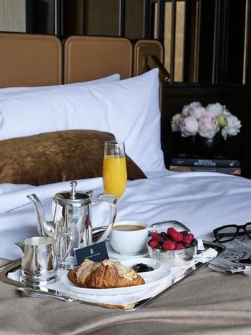 Frühstückstablett im Bett mit Croissant, Orangensaft und Kaffee