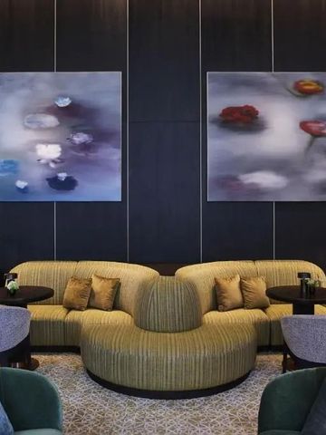 Modern eingerichtete Lounge mit stilvollen Möbeln und abstrakten Gemälden