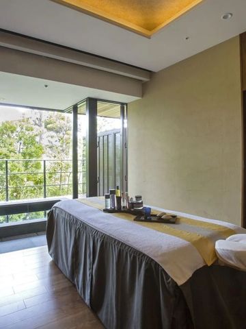 Wellnessraum mit Behandlungsliege und Blick ins Grüne