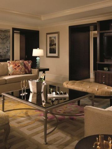 Luxuriöse Suite mit stilvoller Einrichtung und Champagner auf dem Tisch.