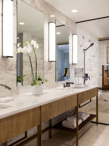 Luxuriöses Badezimmer mit großer Spiegelwand und Orchideen