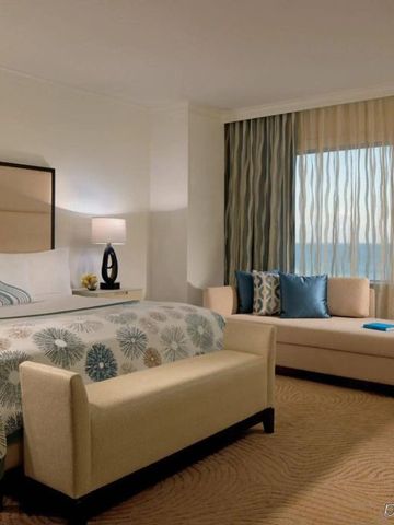 Großzügiges Zimmer mit einem Doppelbett, Sitzecke und Meerblick