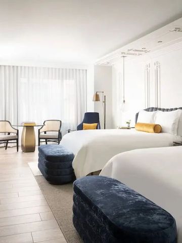 Helles Zimmer mit zwei Doppelbetten und Sitzgelegenheit