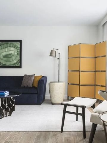 Elegantes Wohnzimmer in einer Hotelsuite mit modernem Dekor und großem Fenster