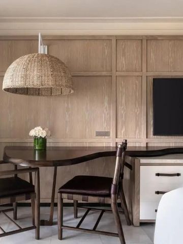 Moderner Essbereich im Hotelzimmer mit Holztisch und Korblampe