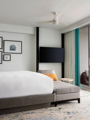 Modernes Hotelzimmer mit Blick auf das Meer durch eine Glaswand.