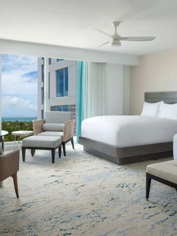 Zimmer mit großen Fenstern und Blick auf das Meer und die Umgebung.