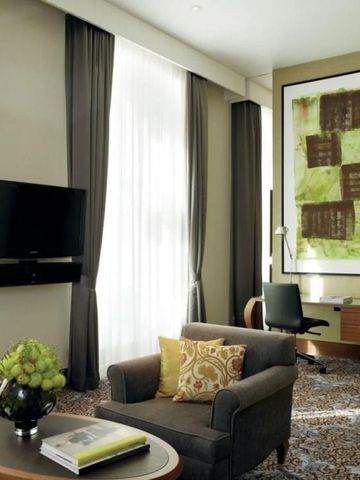 Elegantes Hotelzimmer mit moderner Kunst und grauen Polstermöbeln