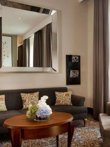 Elegantes Wohnzimmer in einer Suite mit modernen Möbeln und großem Spiegel