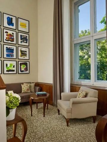 Helle Sitzecke mit großen Fenstern und moderner Kunst an der Wand