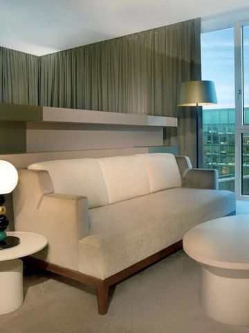 Modernes Hotelzimmer mit Sofa und Ausblick durch große Fenster