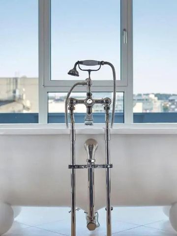 Luxuriöse freistehende Badewanne mit Blick auf die Stadt