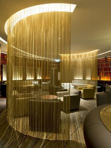 Elegante Lounge mit moderner Beleuchtung und geschmackvollen Trennelementen