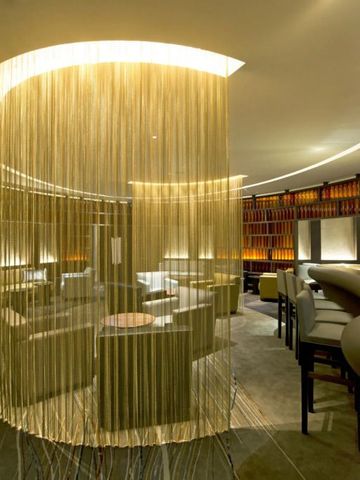 Moderne Lounge mit geschwungenen Trennelementen und stilvoller Einrichtung