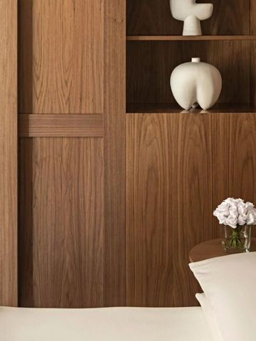 Modernes Hotelzimmer-Design mit Holzverkleidung und dekorativen Vasen