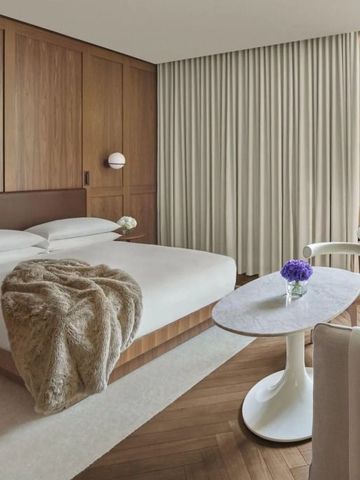 Geräumiges Hotelzimmer mit modernem Mobiliar und Blumenakzenten