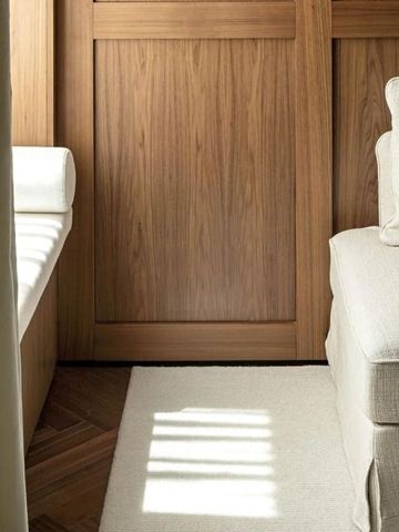 Helle Zimmerecke mit gepolstertem Sitzbereich und dezenter Beleuchtung