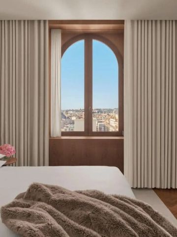 Modernes Hotelzimmer mit großem Fenster und Blick auf die Stadt
