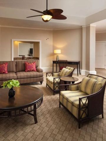 Geräumiges Wohnzimmer einer Suite mit stilvollen Möbeln und Teppichboden.