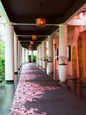 Eleganter Hotelkorridor mit Säulen und Teppich im The Royal Hawaiian