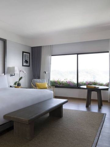 Geräumiges Zimmer mit großem Fenster und Blumenblick.