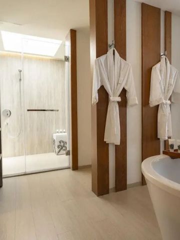 Modernes Badezimmer mit Annehmlichkeiten und Bademänteln