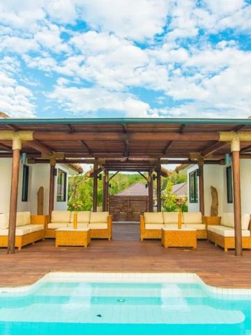 Offener Lounge-Pavillon am Pool mit gemütlichen Sitzgelegenheiten im Freien