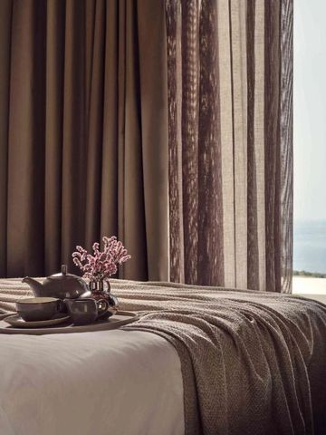 Elegantes Hotelzimmer mit Blick auf das Meer durch bodentiefe Fenster