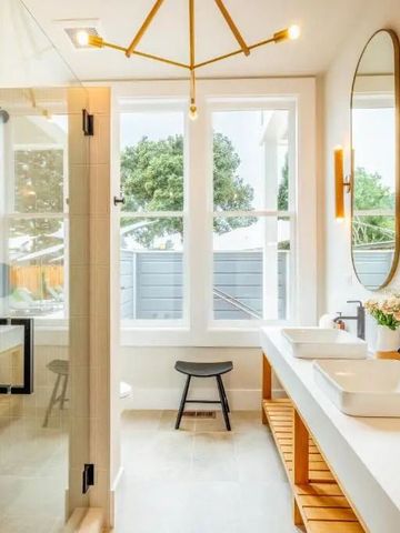 Helles, modernes Badezimmer mit großen Fenstern und eleganten Armaturen